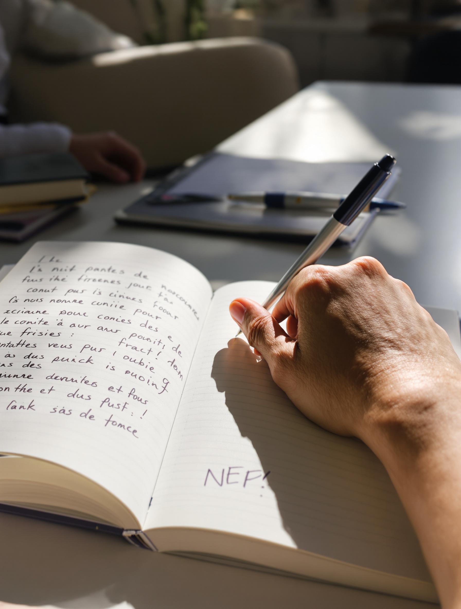 main posée sur un carnet rempli de questions lors d'une consultation nutritionnelle