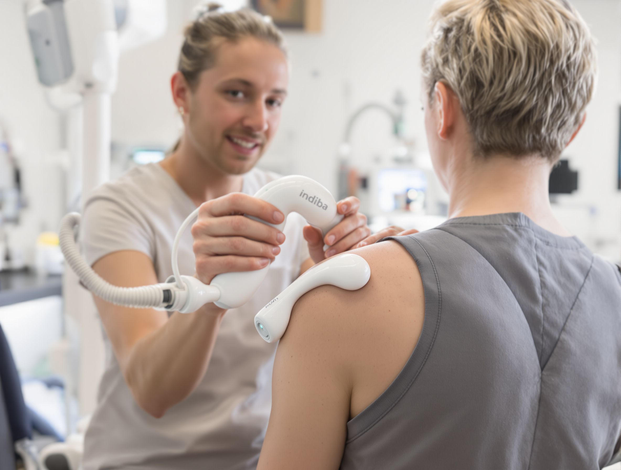 Kinésithérapeute utilisant un appareil Indiba Activ sur l'épaule d'un patient